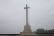 The cross stands tall overlooking the cemetery.