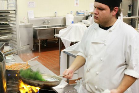 Professional Cook Training student Tylor Brown prepares the veggies for the main course.