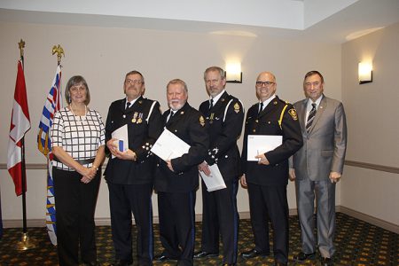 Nelson Police Board Chair and Mayor Deb Kozak and NDP Board Director Am Naqvi (far right) present Long-Service Awards to, from left, Retired Cst. Bill Andreaschuk, Retired Cst. Paul Jacobsen, Cst. Dave Liang and NPD Chief Constable Paul Burkart.